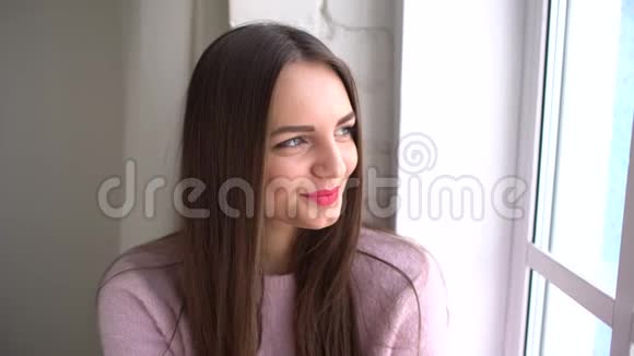 一个可爱的女孩或青少年的生活带着欢笑和快乐的微笑在家的房间靠近窗户新鲜的皮肤视频的预览图