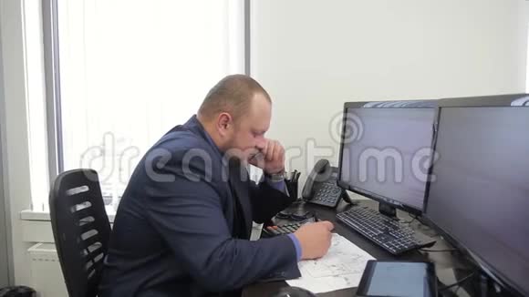 年轻的商人坐在大公司里打电话视频的预览图