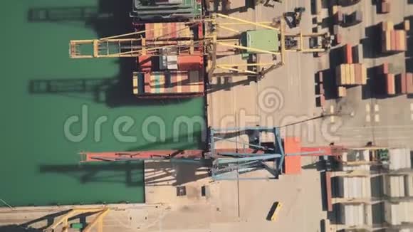 在海港集装箱堆场卸货的大型货船的高空俯视图视频的预览图