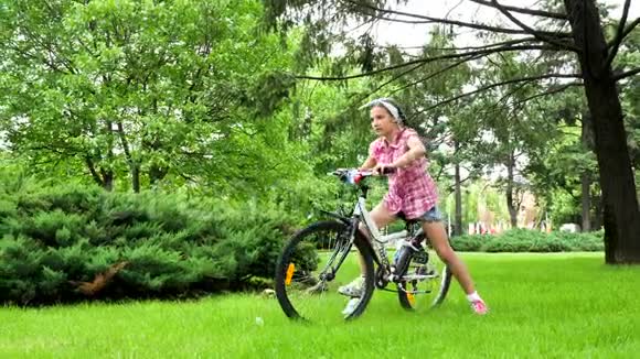 快乐微笑的少女在公园骑自行车视频的预览图