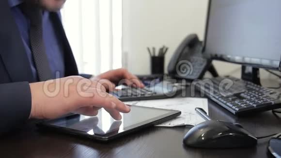 老板用手滚动他平板电脑的屏幕寻找数据并在计算器上计数视频的预览图