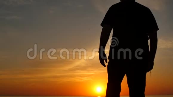 老人在日落时用手表达喜悦慢动作剪影视频的预览图