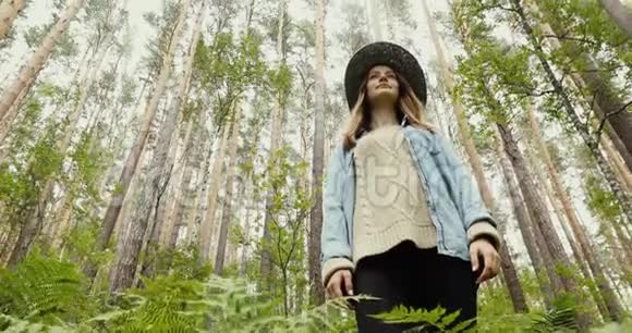 站在高树林中的年轻女子视频的预览图