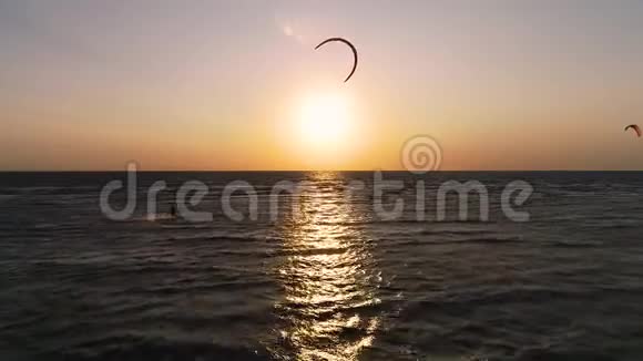 海上日落的鸟瞰一对风筝在海浪中飞翔视频的预览图