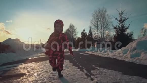 快乐的小女孩跑在公园的雪道上视频的预览图