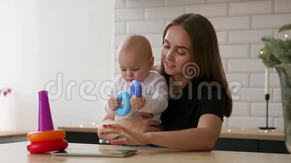 家庭技术和母性概念快乐的年轻母亲带着小宝宝和平板电脑在家视频的预览图