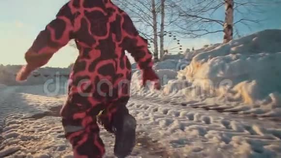 快乐的小女孩跑在公园的雪道上视频的预览图