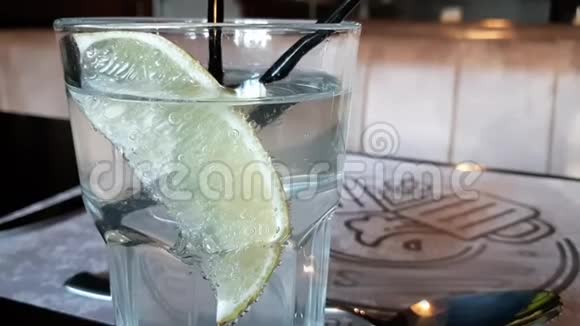 杯中的一片橙子里面有闪闪发光的水一杯水和一片柠檬视频的预览图