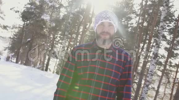 冬天森林里一个蓄着胡须的微笑男人横臂的画像视频的预览图