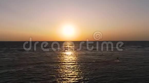 橙色的日落在海上一个孤独的人表演风筝冲浪飞上空中视频的预览图