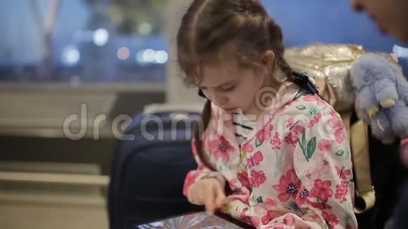 那个带着平板电脑的小女孩在机场等你的航班视频的预览图