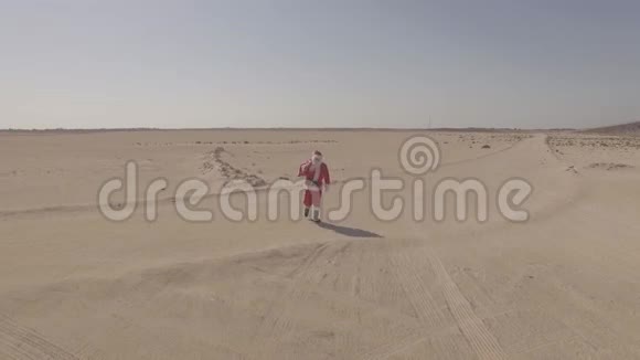 空中观景无人机空中射击圣诞老人带着麻袋走在沙滩上在沙漠里找到了沥青路日志简介科摩罗视频的预览图