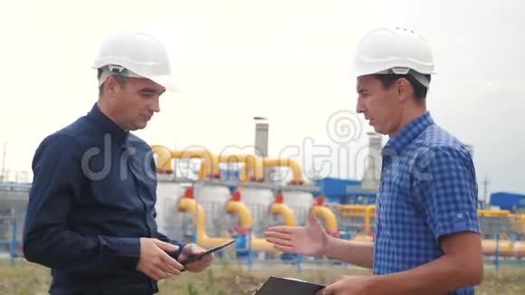 团队合作制气站理念慢动作视频两名戴头盔的工程师在天然气供应上握手视频的预览图