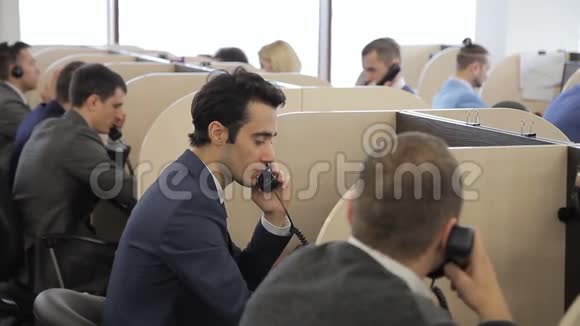 在办公室里男人穿着西装工作通过电话交流视频的预览图
