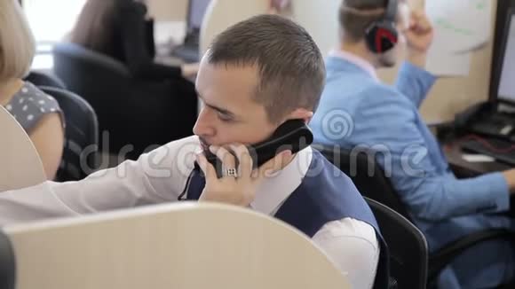 在大办公室里与客户进行电话交谈的经理的画像视频的预览图