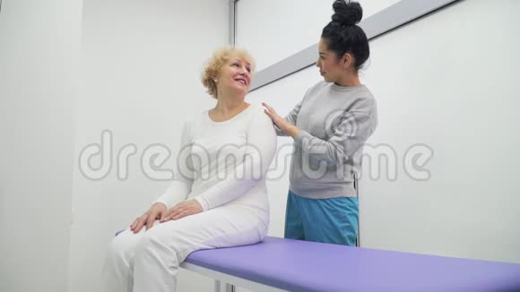 年轻医生在诊所里和老年妇女谈话视频的预览图