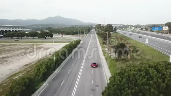 在葡萄牙高速公路上的鸟瞰图红色汽车沿着一条自由的道路绕着树行驶视频的预览图