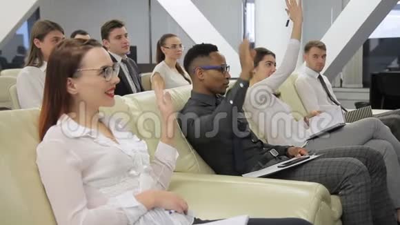 商人们举手询问会议上的问题视频的预览图