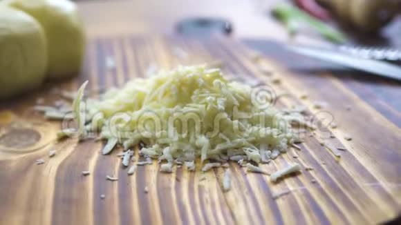 烤奶酪落在木桌特写上在烤炉上加工光栅奶酪烹饪意大利面的新鲜配料视频的预览图