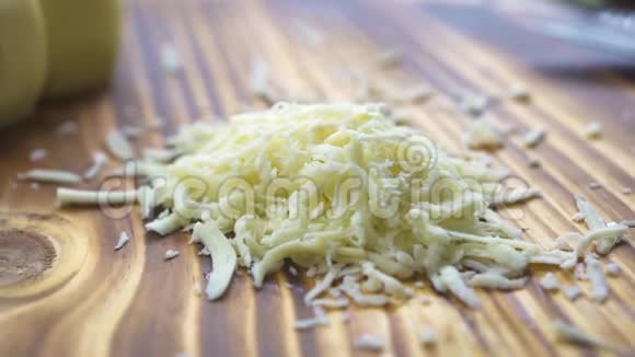 木制桌子上的烤奶酪贴在一起在厨房板上加工光栅乳制品奶酪烹饪原料视频的预览图