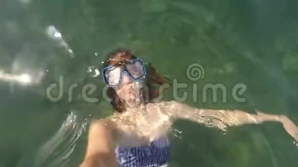 棕色头发的年轻女子在水下自拍带着游泳游泳面罩在海里或海洋蓝水中浮潜没有角甲虫视频的预览图