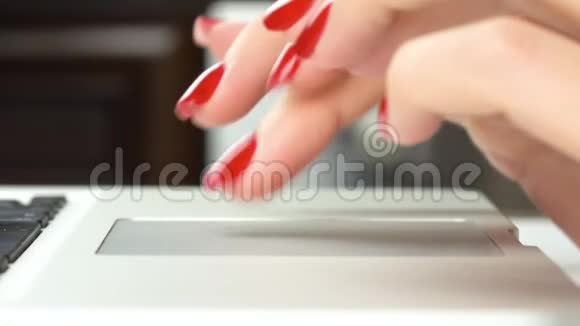 4K镜头女人的手红色指甲使用和点击便携式电脑轨迹板侧视特写视频的预览图