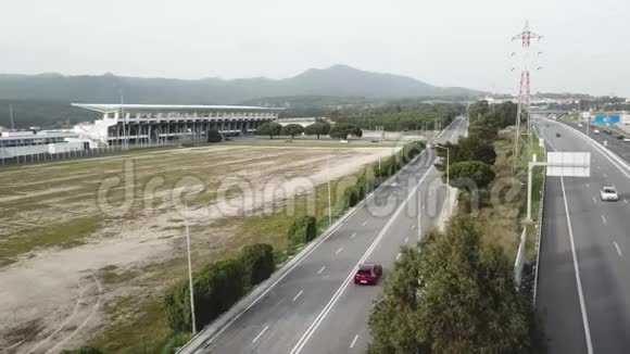 在葡萄牙高速公路上的鸟瞰图红色汽车沿着一条自由的道路绕着树行驶视频的预览图