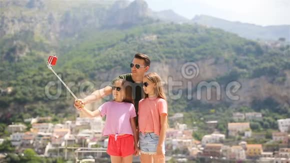 阿马尔菲海岸伊塔利的波西塔诺小镇上父亲和孩子在拍摄自拍照片视频的预览图