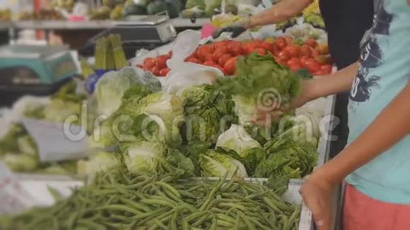 十几岁的男孩在水果和蔬菜农村市场选择生菜视频的预览图