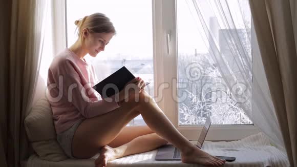 梦中的小女孩在家坐在窗台上看书外面冬天视频的预览图