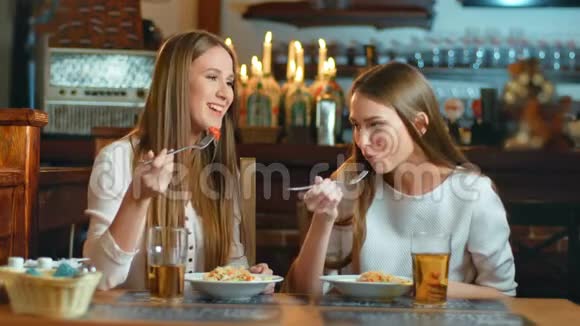 两个微笑的年轻女人在餐馆吃午饭视频的预览图