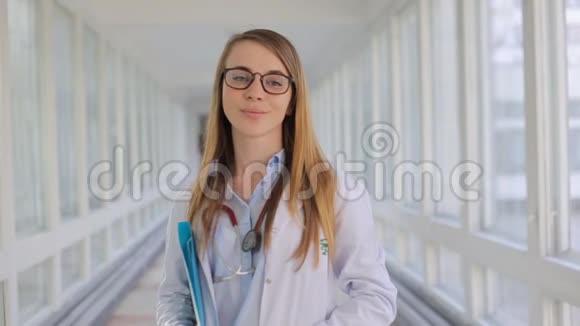 年轻迷人的女医生对着室内的摄像机微笑视频的预览图