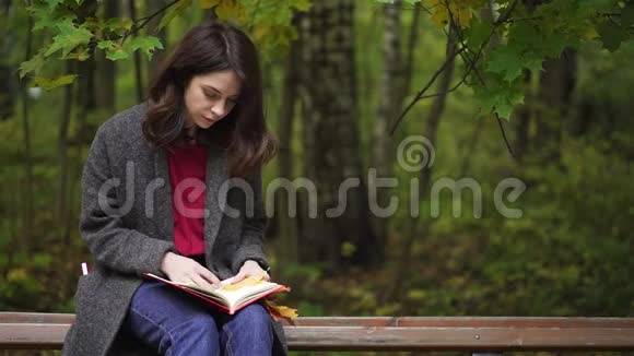 秋天公园里一个冷静的黑发女人在看书视频的预览图