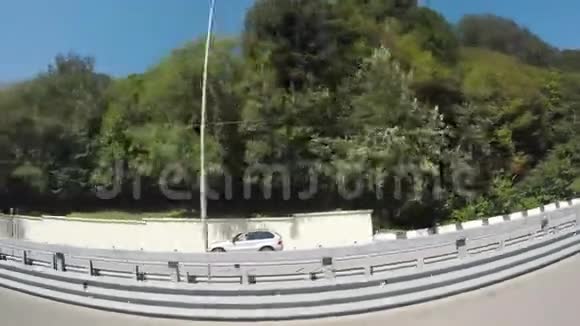 从绿色山丘上的车窗观看在平行道路和蓝天上驾驶车辆以色列菲舍耶效果场景视频的预览图
