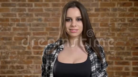 年轻漂亮的漂亮女人长发直对着镜头微笑女建筑工人砖背景视频的预览图