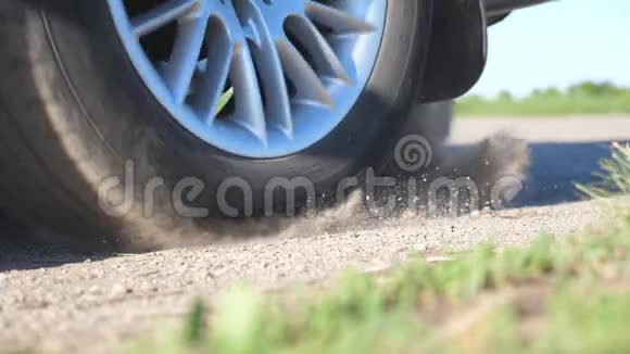 汽车车轮在运动开始时在土路上打滑小石头和泥土从轮胎下面飞出来视频的预览图