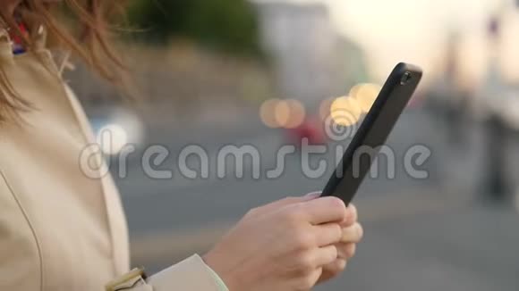 女人手拿智能手机对着汽车前灯视频的预览图