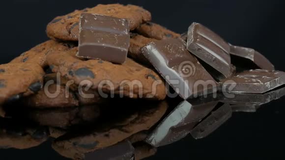 时尚黑色背景和镜面上的巧克力饼干和巧克力片视频的预览图
