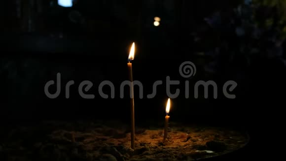 两支蜡烛矗立在东正教古暗寺的沙地上视频的预览图
