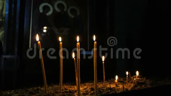蜡烛燃烧站在沙滩上的古寺东正教教堂的图标背景上视频的预览图