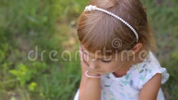 绿色草地背景下公园里微笑的小女孩的肖像异色差视频的预览图