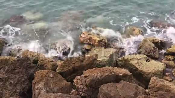 强烈的波浪溅在石头上海浪撞击岩石海岸海洋溅到岩石上视频的预览图