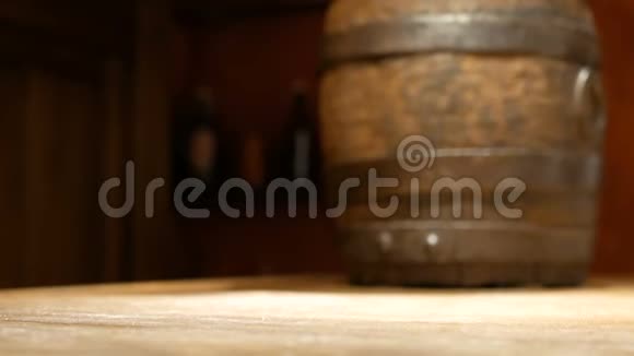 人的手把一个旧的木制啤酒杯放在桌子上的背景上一个小桶喝饮料酒馆里的菜视频的预览图