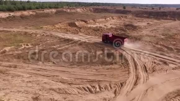 高空为红色大货车在地面采石场行驶背后有飞尘行业理念场景空卡车视频的预览图