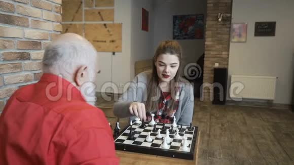 年轻女孩在祖父手里赢了一盘棋视频的预览图