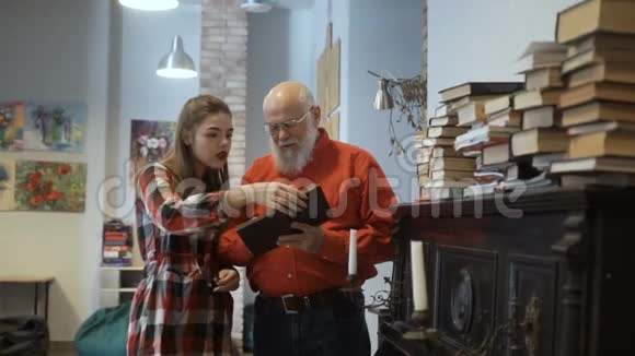 白发苍苍的祖父和孙女一起读一本有趣的书视频的预览图