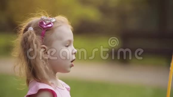 自信活泼可爱的小女孩吹巨大的空气肥皂泡吹风机中型特写视频的预览图