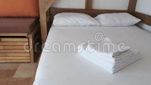 一张舒适的床房间里有白色的床单毛巾和枕头等待新的度假者视频的预览图