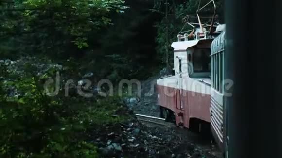 在森林里沿着狭窄的铁路在一辆旧旅游火车上旅行视频的预览图