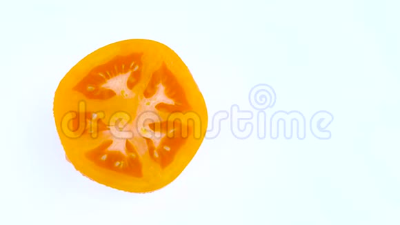 一半框架的顶部从上面的一个切割在一半橙色黄色番茄与水滴在转盘上旋转视频的预览图